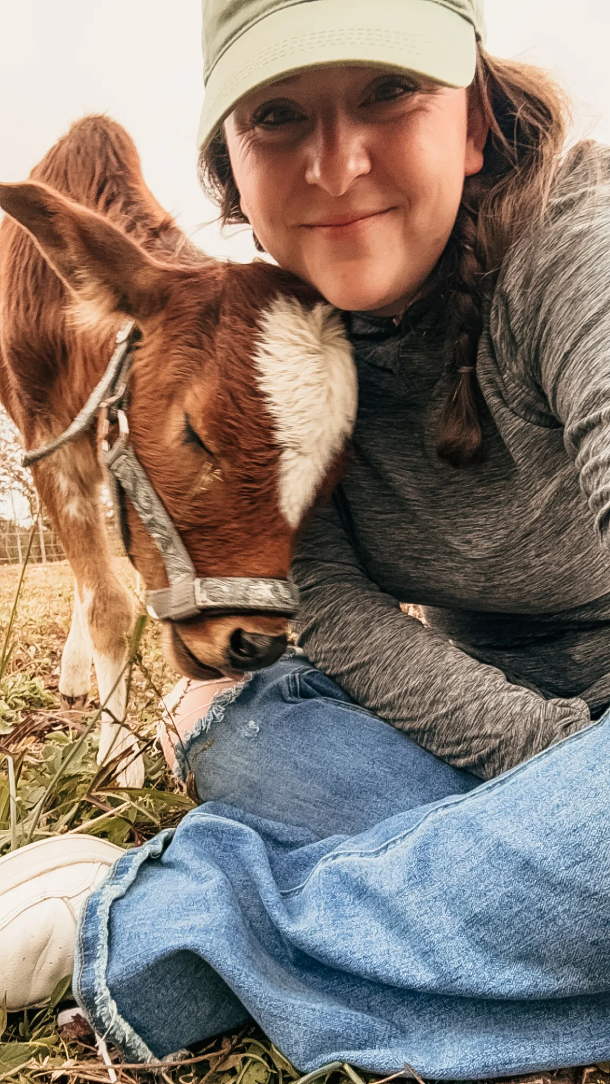 A woman nuzzling a young calf at Magnolia Hill